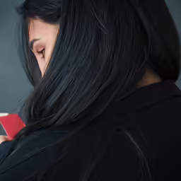 a woman looking down at her cell phone