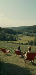 people are sitting on lawn chairs in a field