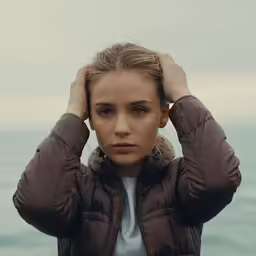 a beautiful young lady with long hair holding her hair up