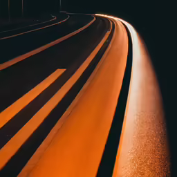 cars driving down a highway in the dark