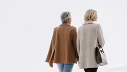 two people walking down a snowy street looking into the distance