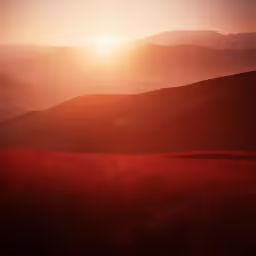 the sun is setting in a very dark field
