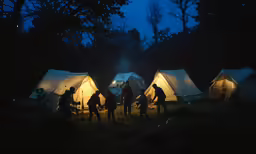 many tents and one of them have several lit up tents in the dark