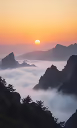 an orange sunset in the mountains and some clouds