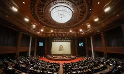 a large auditorium with many people sitting in chairs