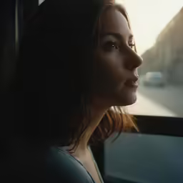 the woman is sitting in her car looking out the window
