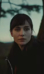 a woman looking into the distance with one eye closed