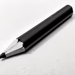 black and silver pen sitting on top of a white surface