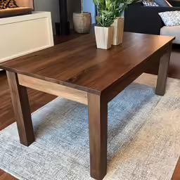 the coffee table is on a white rug in front of a couch