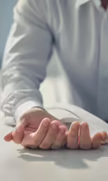 hands folded on desk with text over top
