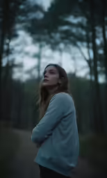 a beautiful young woman standing in the forest