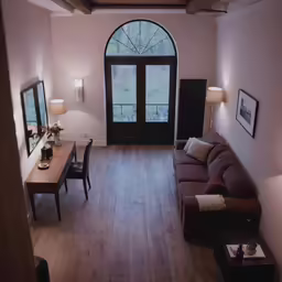 an empty living room with large arched window