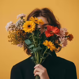 a woman is holding up flowers over her face