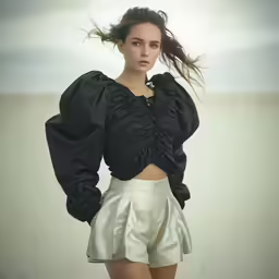 young woman posing while wearing short skirt with top with ruffle
