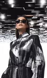 a woman in a white and black dress posing under a ceiling