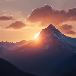 the sun is shining brightly above a mountain peak