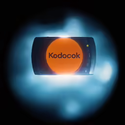 a phone sitting in front of an orange light that reads kodoook