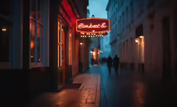 the entrance to a hotel on a cobblestone street at night