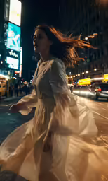 a woman is running through the street at night