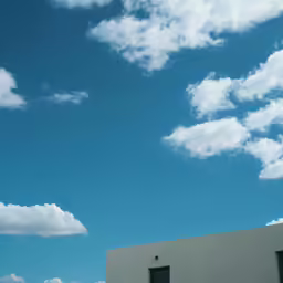 a building with the door open is surrounded by clouds