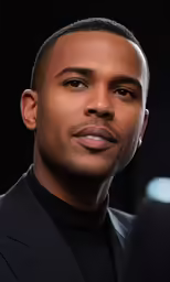 the african american man wearing a black suit poses for a picture