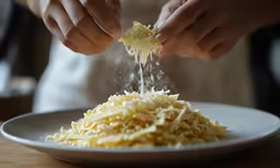 a person adding food to a white plate