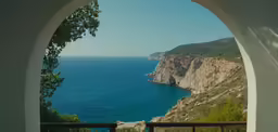 the view from inside of an arch shows a body of water