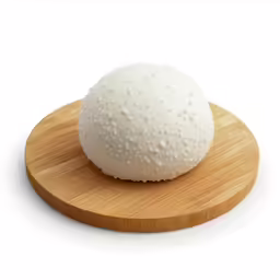 large round white ball sitting on wooden platter