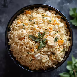 a pasta dish with chicken and oranges in a black bowl