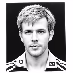 the young man is wearing a jacket and is looking straight ahead
