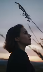 a woman with a single flower next to a tree