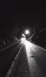a empty street is shown at night with the headlights on