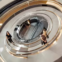 three women on escalator at a shopping mall