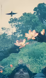 a woman holding pink flowers in her hands as a bird flies overhead