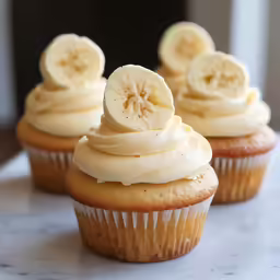 three cup cakes with banana slices on top