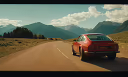 an automobile driving on a desert road near the mountains