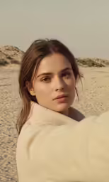 the young girl is taking a selfie on the beach
