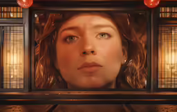 there is a woman looking through a wooden frame
