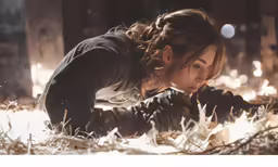 a person kneeling on top of hay in a building
