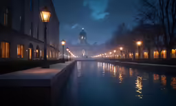 a walkway is along side a body of water with lights on the buildings