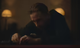 man in dark room typing on his phone
