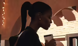 a girl using a phone in an indoor space