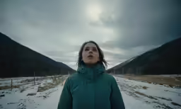 a woman standing in the middle of an open field