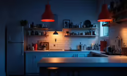 a kitchen with two hanging lights above the stove