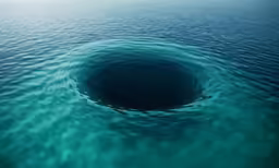 a large deep blue hole sits under the ocean