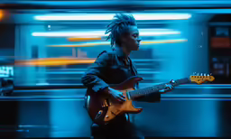 a man in black outfit playing guitar with bright blue and yellow lights