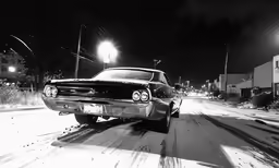 a black and white photo of a car on a snowy road