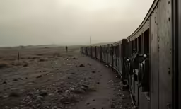 a train is moving along the tracks on the dirt