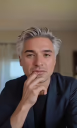 a man is staring at something while holding his hand to his face