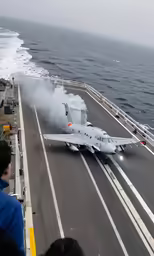 people watching a fighter jet aircraft on an aircraft carrier